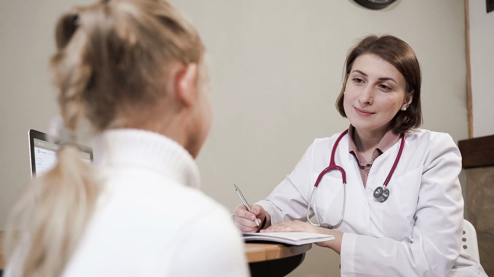 Une médecin prend des notes face à une patiente